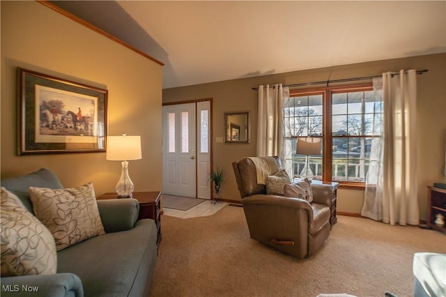 living area featuring vaulted ceiling, light tile patterned flooring, light colored carpet, and baseboards