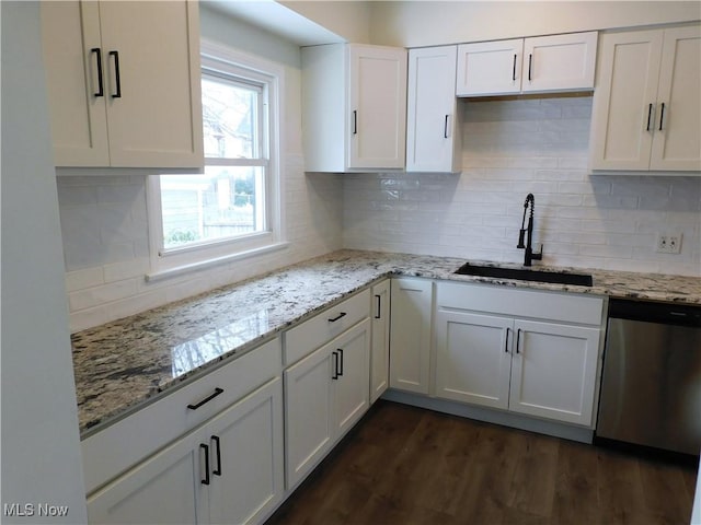 kitchen featuring dark wood-type flooring, a sink, backsplash, white cabinets, and dishwasher