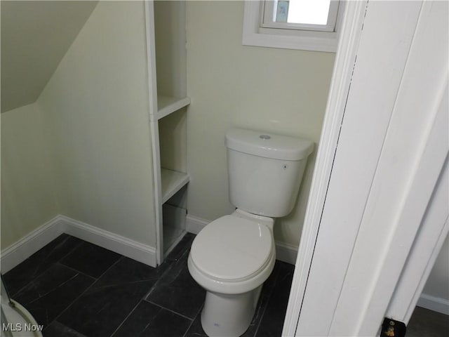 bathroom featuring toilet and baseboards