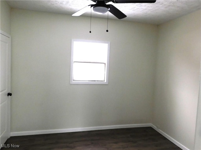 spare room with baseboards, a textured ceiling, ceiling fan, and dark wood-style flooring