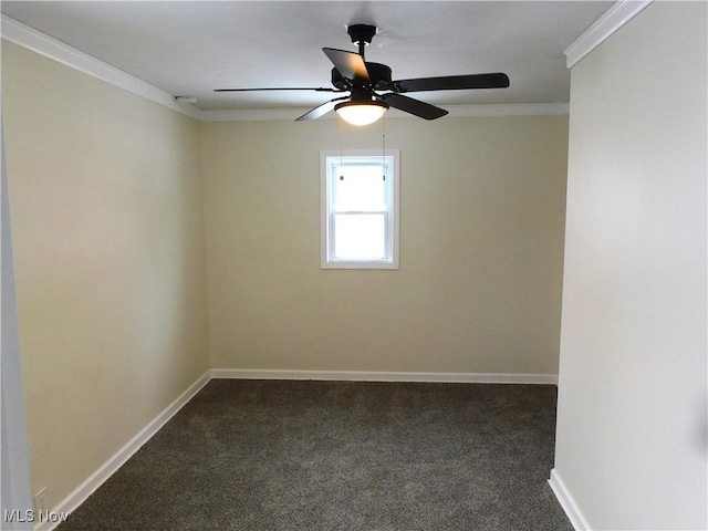 empty room with dark colored carpet, baseboards, ceiling fan, and crown molding