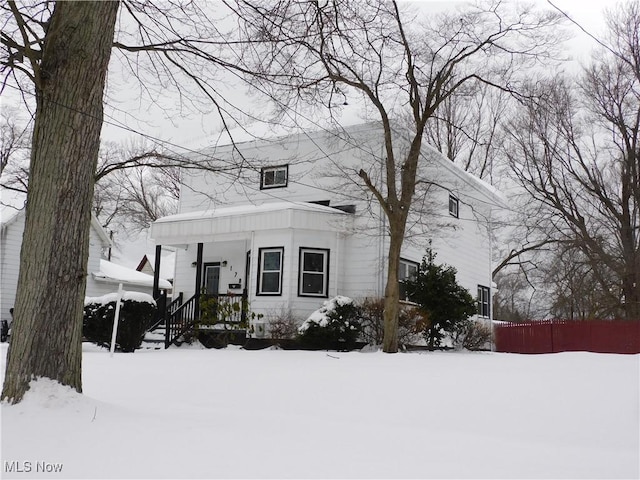 view of front of home with covered porch and fence