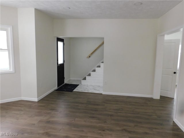 foyer featuring stairs, baseboards, and wood finished floors