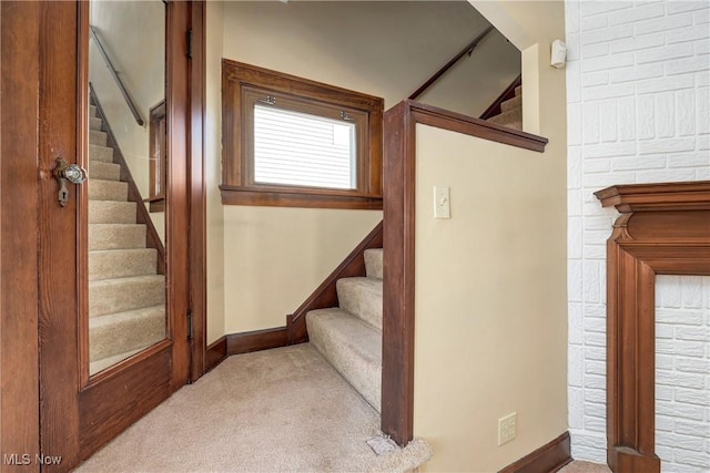 stairway featuring baseboards and carpet floors