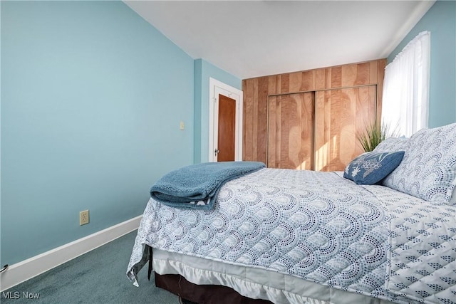 carpeted bedroom featuring a closet and baseboards