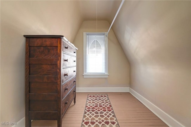 bonus room with baseboards, lofted ceiling, and wood finished floors