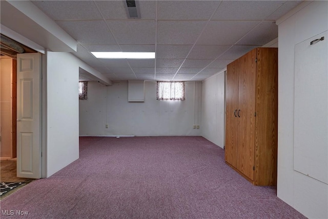 below grade area featuring carpet flooring, visible vents, and a drop ceiling