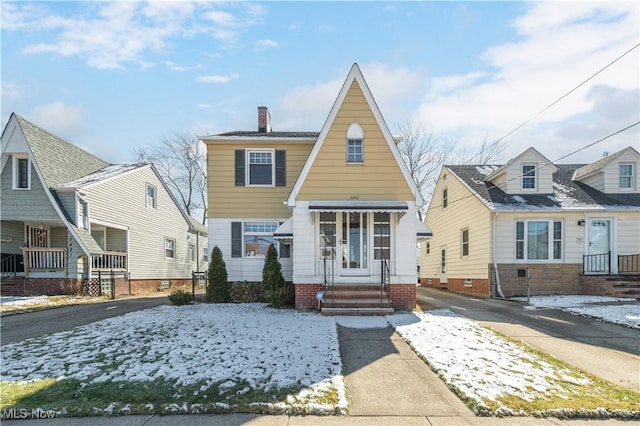 view of front of home with entry steps and a chimney