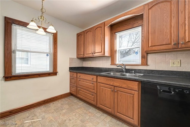 kitchen with dark countertops, a healthy amount of sunlight, dishwasher, and a sink