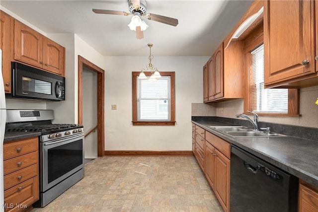 kitchen with a sink, dark countertops, black appliances, and a healthy amount of sunlight