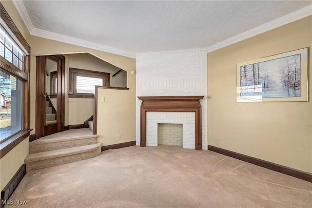 unfurnished living room featuring a brick fireplace, carpet, stairway, ornamental molding, and a textured ceiling