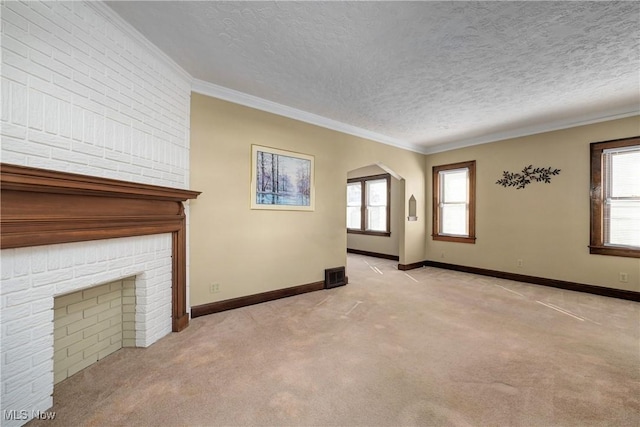 unfurnished living room with visible vents, a healthy amount of sunlight, and crown molding