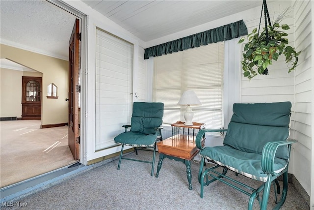 sitting room featuring visible vents, crown molding, baseboards, carpet flooring, and a textured ceiling