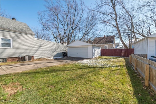 view of yard featuring an outbuilding, central AC unit, fence, and a detached garage