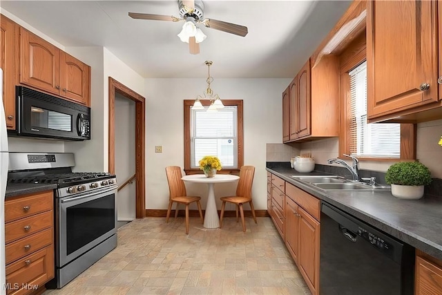 kitchen featuring black appliances, plenty of natural light, dark countertops, and a sink