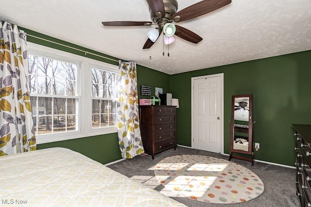 carpeted bedroom featuring ceiling fan, a textured ceiling, and baseboards