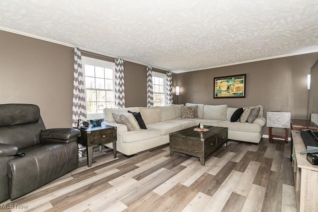 living room featuring baseboards, a textured ceiling, crown molding, and light wood finished floors