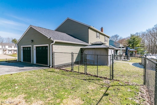 view of side of property featuring fence, roof with shingles, a lawn, and a gate