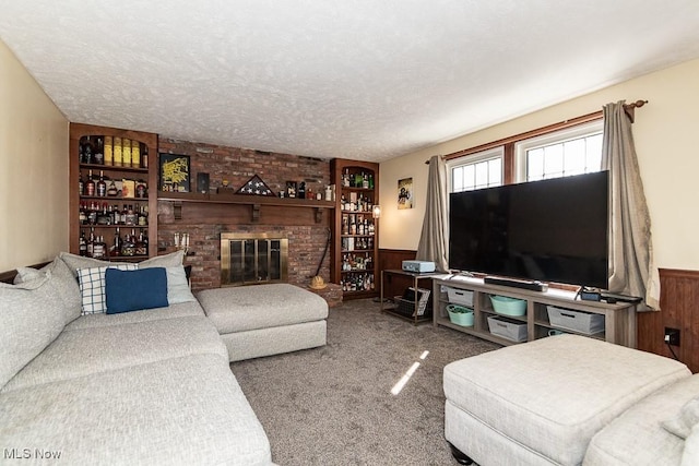 living area with carpet floors, a textured ceiling, wood walls, and wainscoting