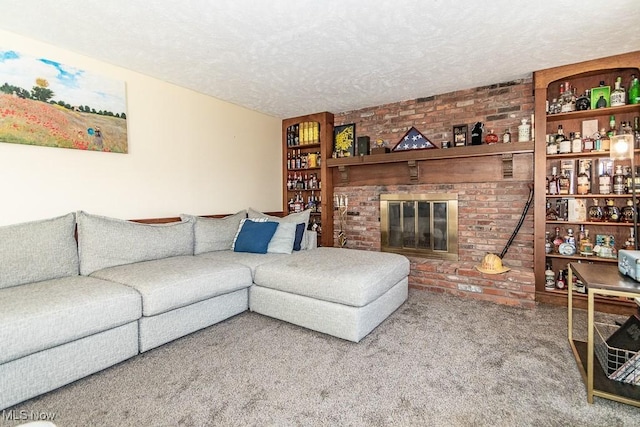 carpeted living room featuring a fireplace, brick wall, and a textured ceiling