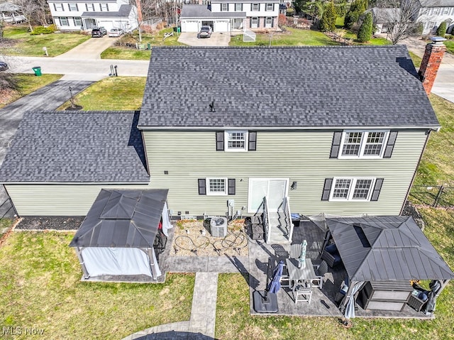 rear view of property featuring a patio, a chimney, and a yard