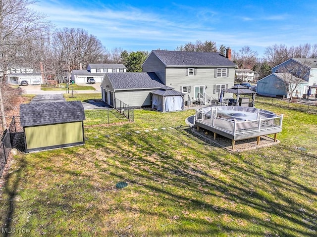 back of property with an outbuilding, fence, a gazebo, a storage unit, and a garage