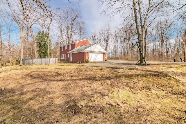 view of yard with a garage and driveway