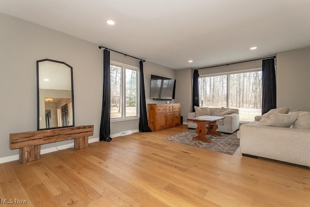 living room with a wealth of natural light, baseboards, light wood-style floors, and recessed lighting