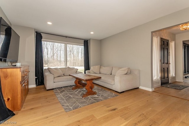 living room with recessed lighting, light wood-type flooring, and baseboards