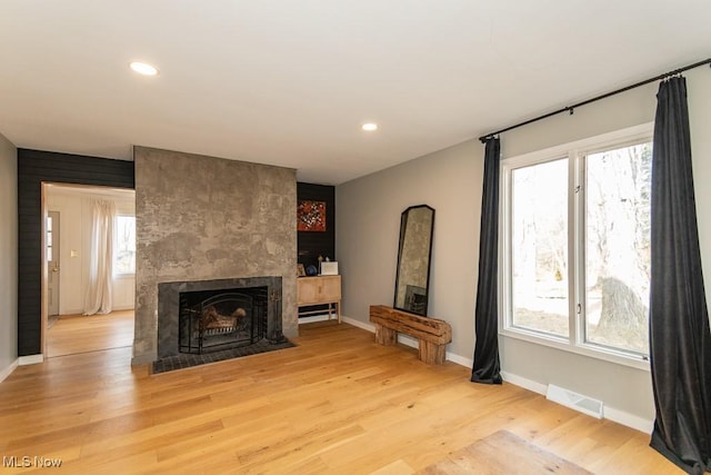 unfurnished living room with visible vents, recessed lighting, a fireplace, and light wood-type flooring