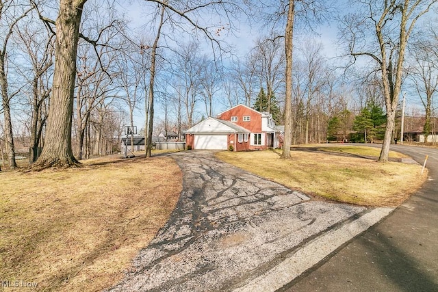 view of front of house with a front lawn, an attached garage, and driveway