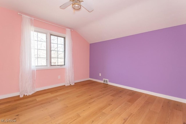 bonus room featuring visible vents, baseboards, ceiling fan, light wood-type flooring, and vaulted ceiling