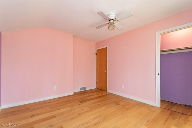 unfurnished bedroom featuring light wood-type flooring, visible vents, a ceiling fan, a closet, and baseboards