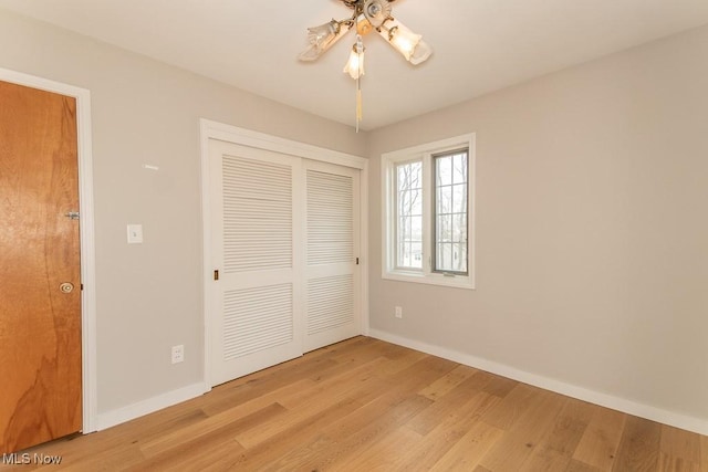 unfurnished bedroom featuring a closet, baseboards, a ceiling fan, and light wood finished floors