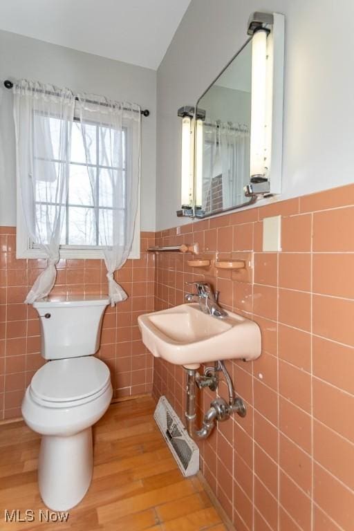 bathroom with wood finished floors, visible vents, a sink, wainscoting, and toilet