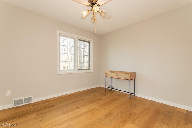 empty room featuring visible vents, baseboards, ceiling fan, and light wood finished floors