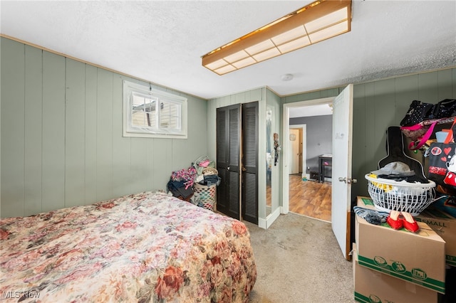 bedroom with light colored carpet and a textured ceiling