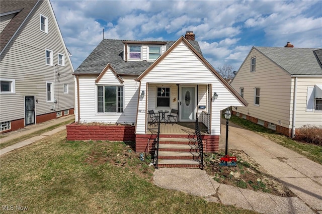 bungalow featuring a front yard, driveway, covered porch, a shingled roof, and a chimney