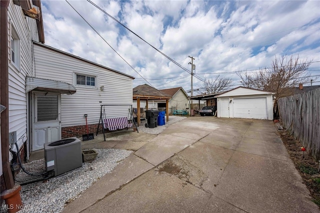 exterior space with a garage, central air condition unit, an outbuilding, and fence