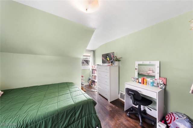 bedroom with lofted ceiling and wood finished floors