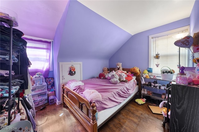 bedroom with lofted ceiling and wood finished floors