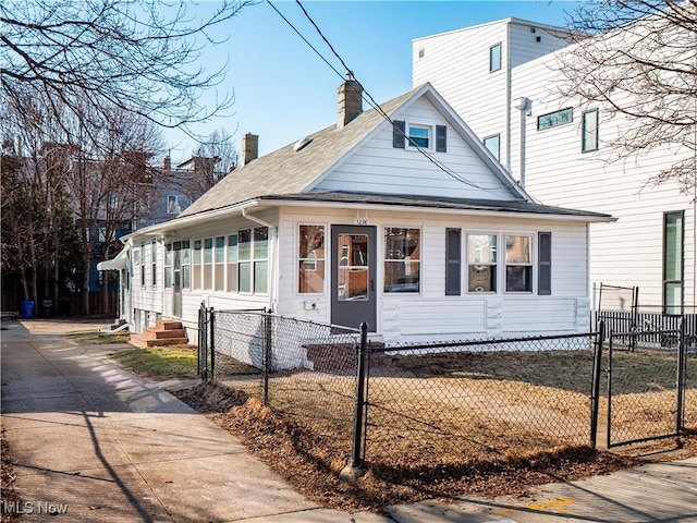 view of front facade with entry steps, a fenced front yard, and a chimney