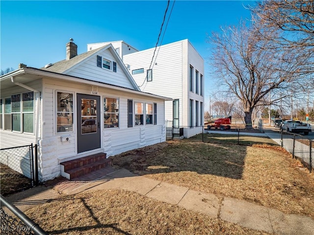 exterior space featuring entry steps, a chimney, and fence