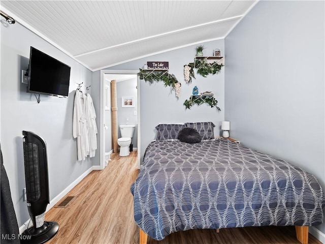 bedroom with visible vents, lofted ceiling, baseboards, and light wood finished floors