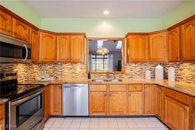 kitchen featuring brown cabinets, appliances with stainless steel finishes, and a sink