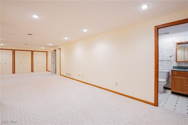 below grade area with baseboards, recessed lighting, visible vents, and light carpet