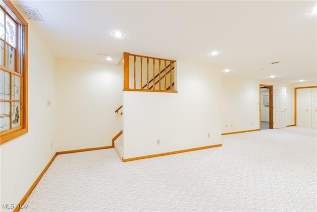 finished below grade area with visible vents, baseboards, carpet, and stairs