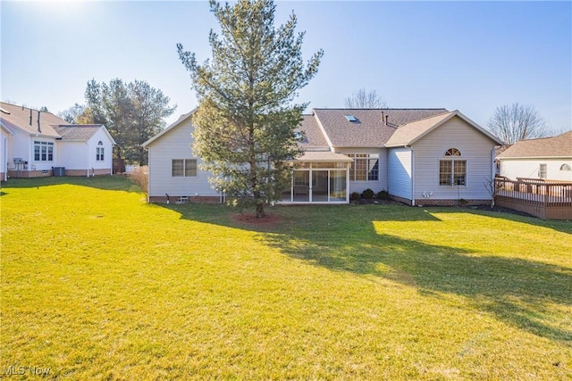 back of house featuring a lawn, a sunroom, and crawl space