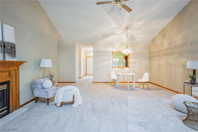 sitting room with a glass covered fireplace, carpet flooring, and vaulted ceiling