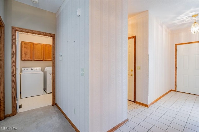 laundry area with baseboards, wallpapered walls, light tile patterned flooring, cabinet space, and washer and dryer